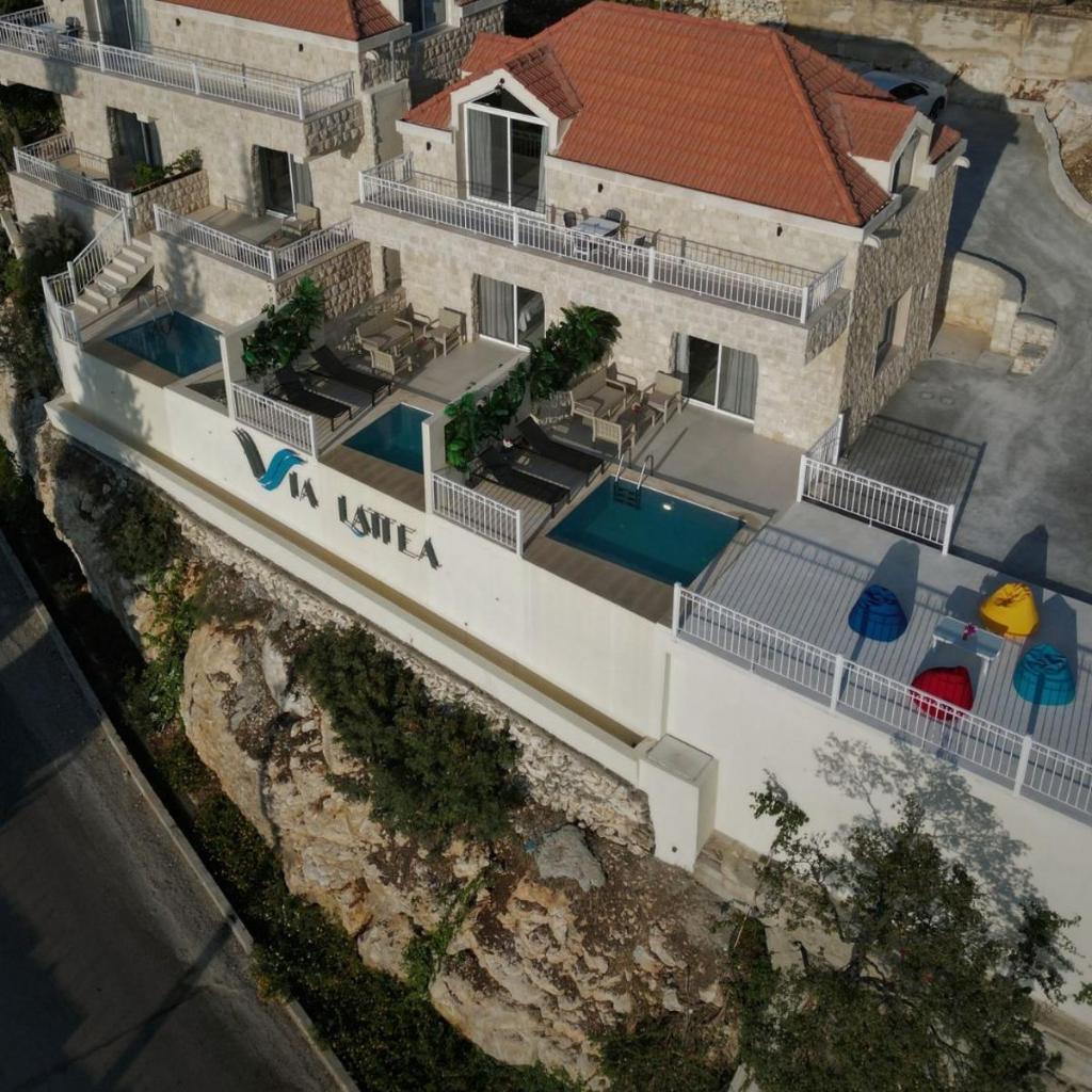 Aerial view of Via Lattea — terracotta roofs, pools and limestone walls