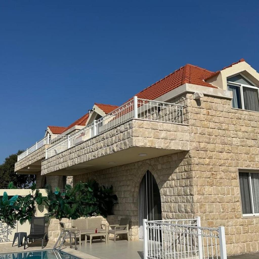 Limestone facade with wrought-iron balconies under blue sky